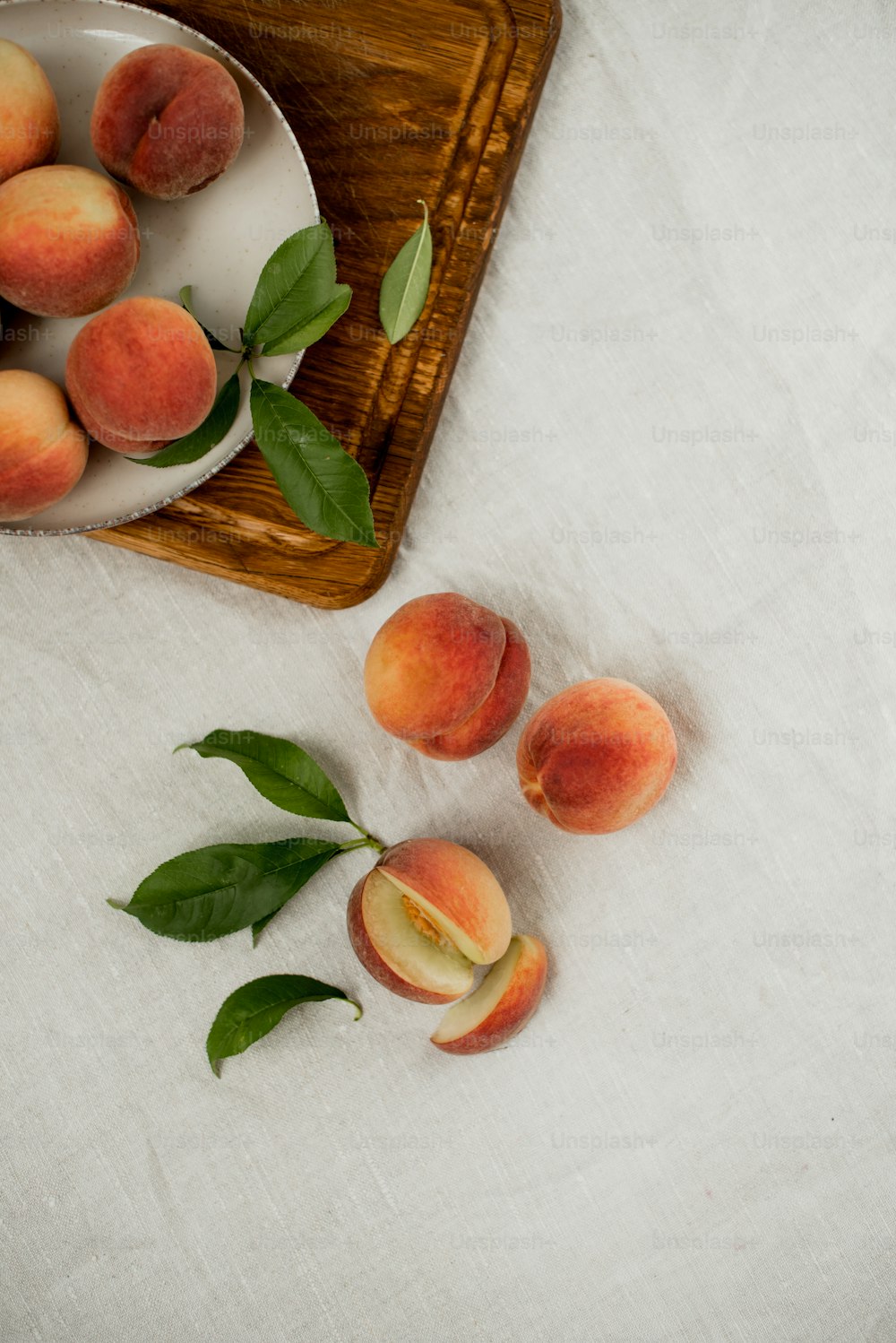 a bowl of peaches on a wooden tray
