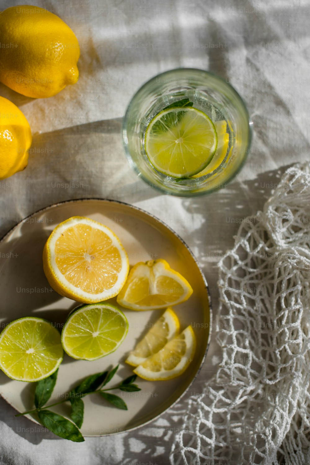 un plato de limones y un vaso de agua