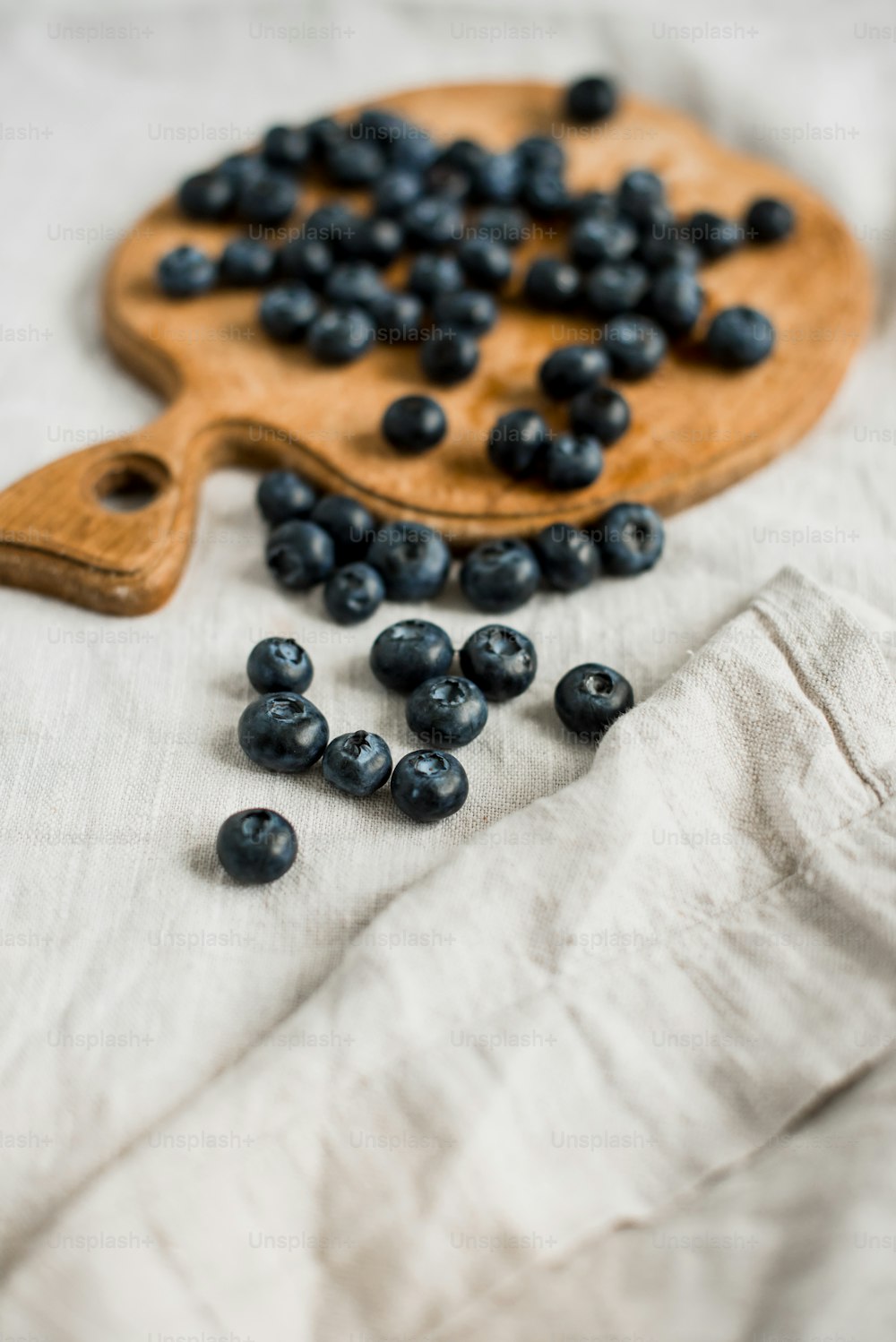 a wooden cutting board with blueberries on it