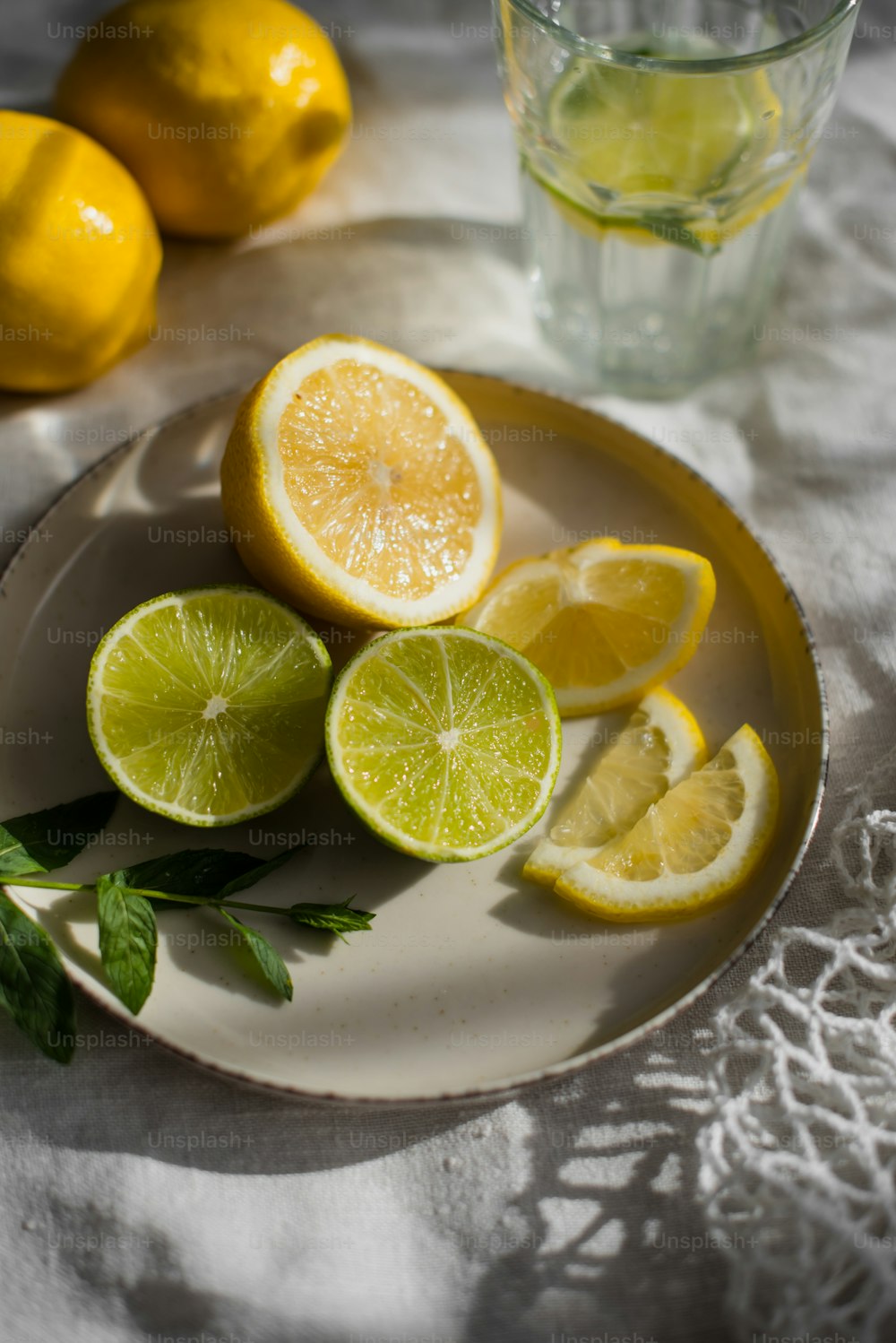 un plato de limones y un vaso de agua
