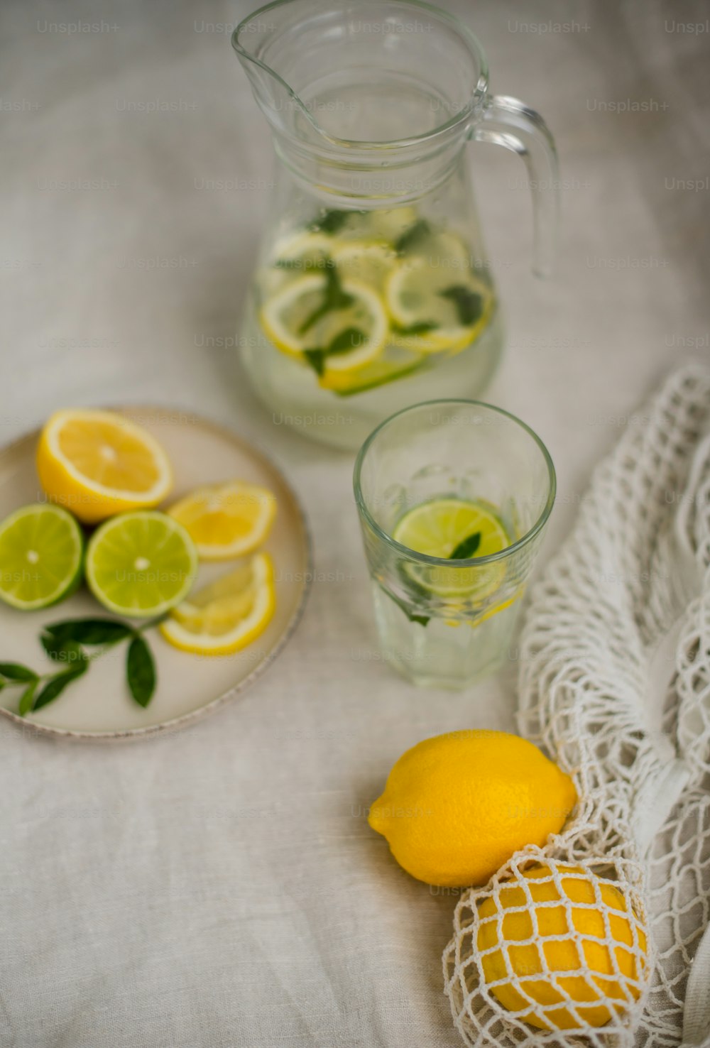 un plato de limones y una jarra de agua