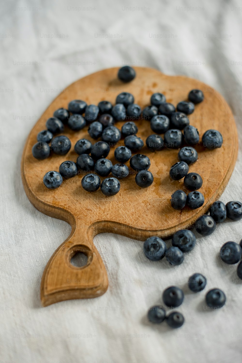 a wooden spatula filled with blueberries on top of a table