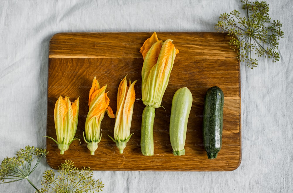 a wooden cutting board topped with zucchini and squash