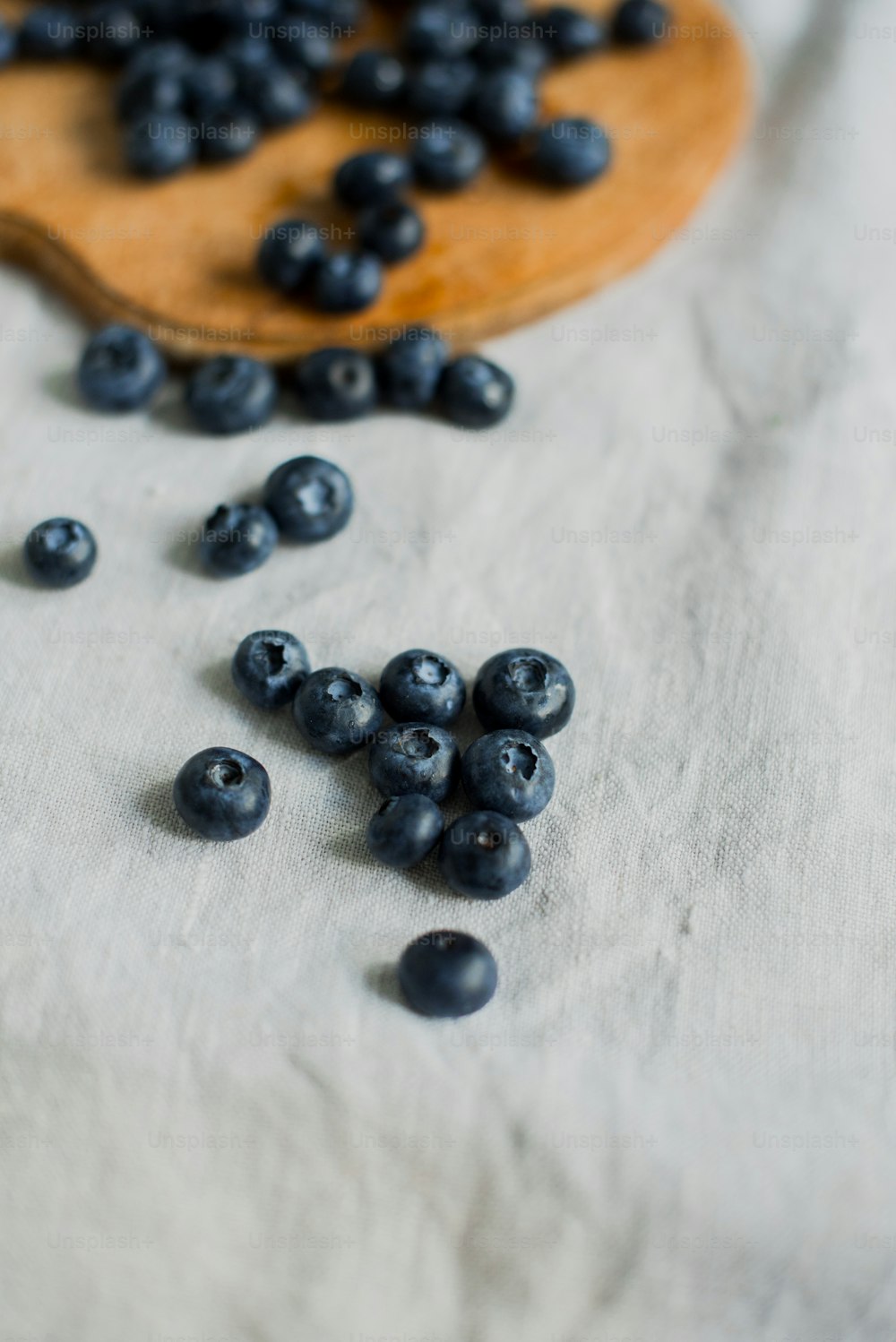 a wooden spoon full of blueberries on a table