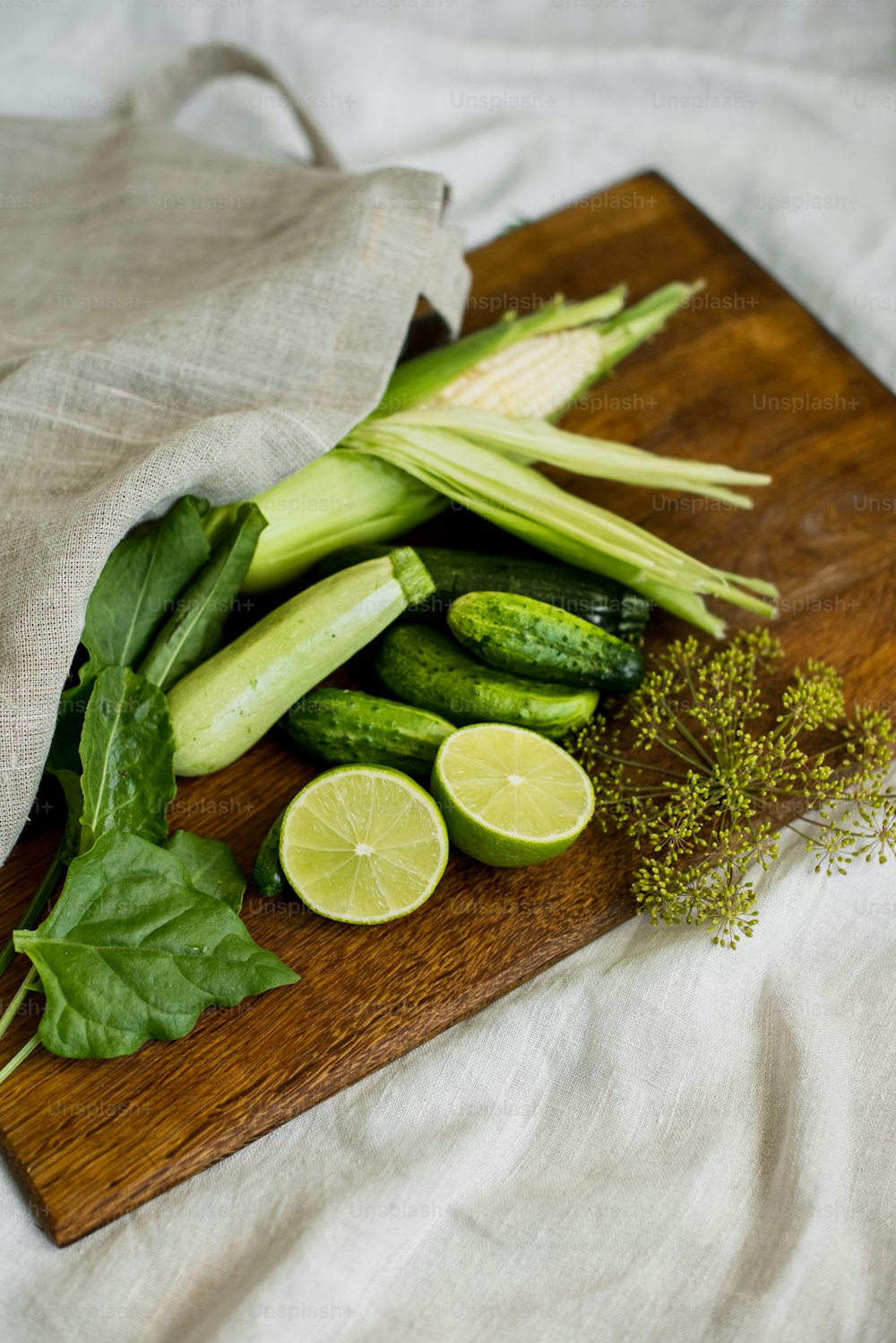 a wooden cutting board topped with green vegetables