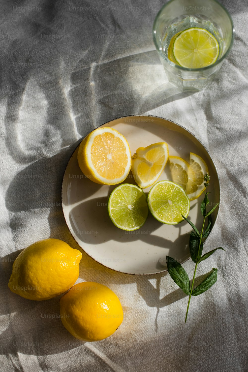 a white plate topped with lemons next to a glass of water