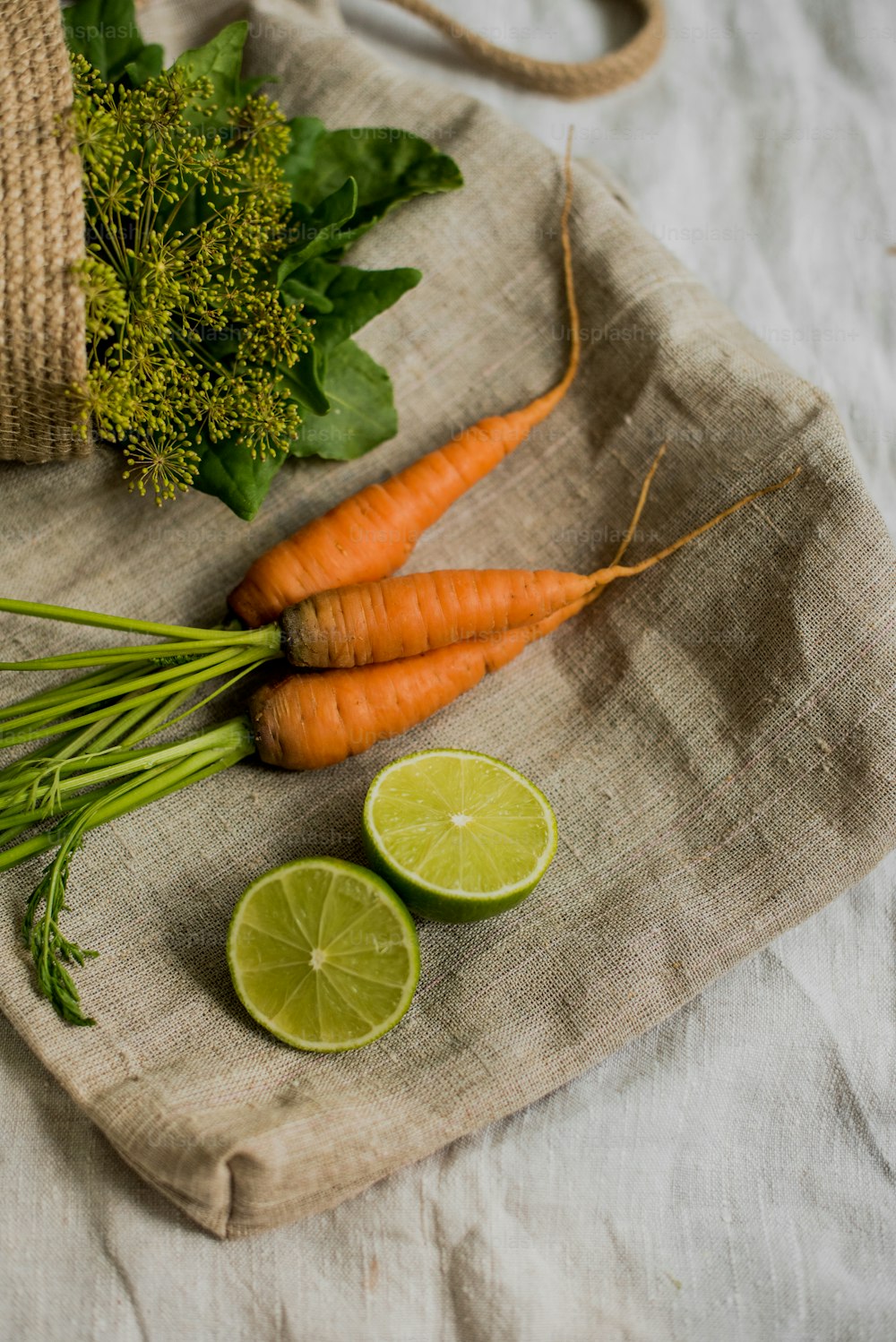 Karotten, Brokkoli und Limetten auf einem Tuch