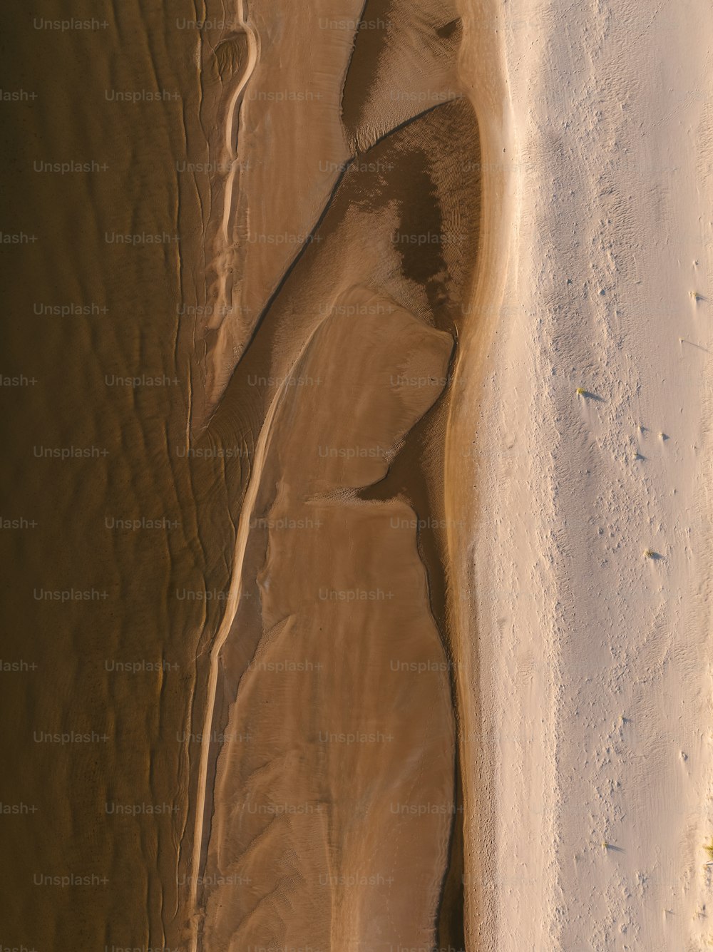 una vista aérea de una playa de arena y un cuerpo de agua