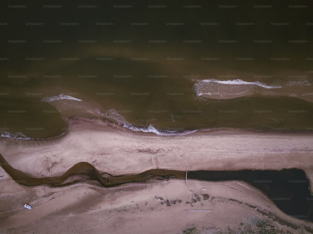 uma vista aérea de uma praia de areia e água