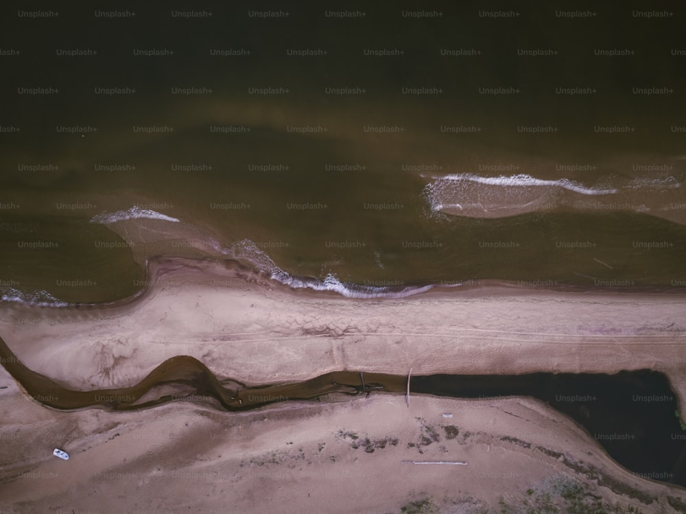 an aerial view of a sandy beach and water