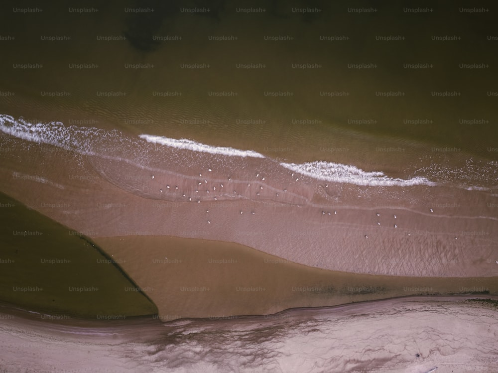 an aerial view of a sandy beach and water