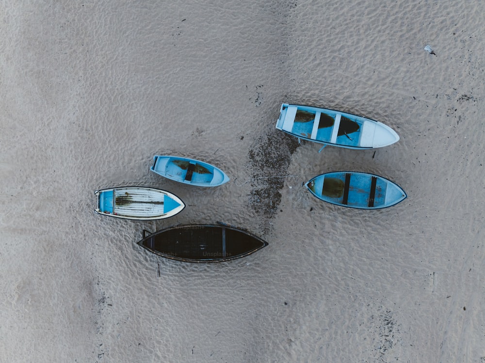 Un gruppo di barche sedute sulla cima di una spiaggia sabbiosa