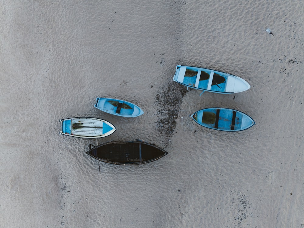 a group of boats sitting on top of a sandy beach