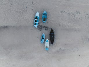 Un grupo de barcos sentados en la cima de una playa de arena