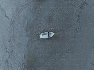 a small boat floating on top of a sandy beach