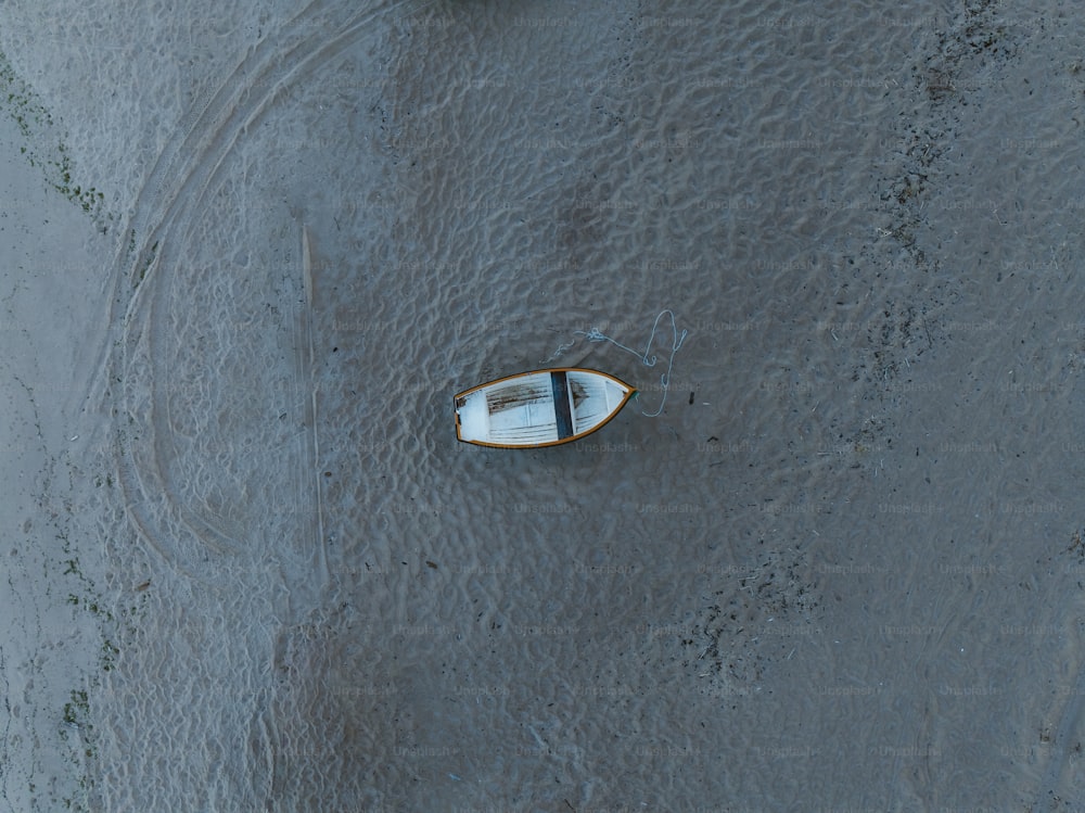 a small boat floating on top of a sandy beach