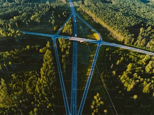 an aerial view of a highway in the middle of a forest