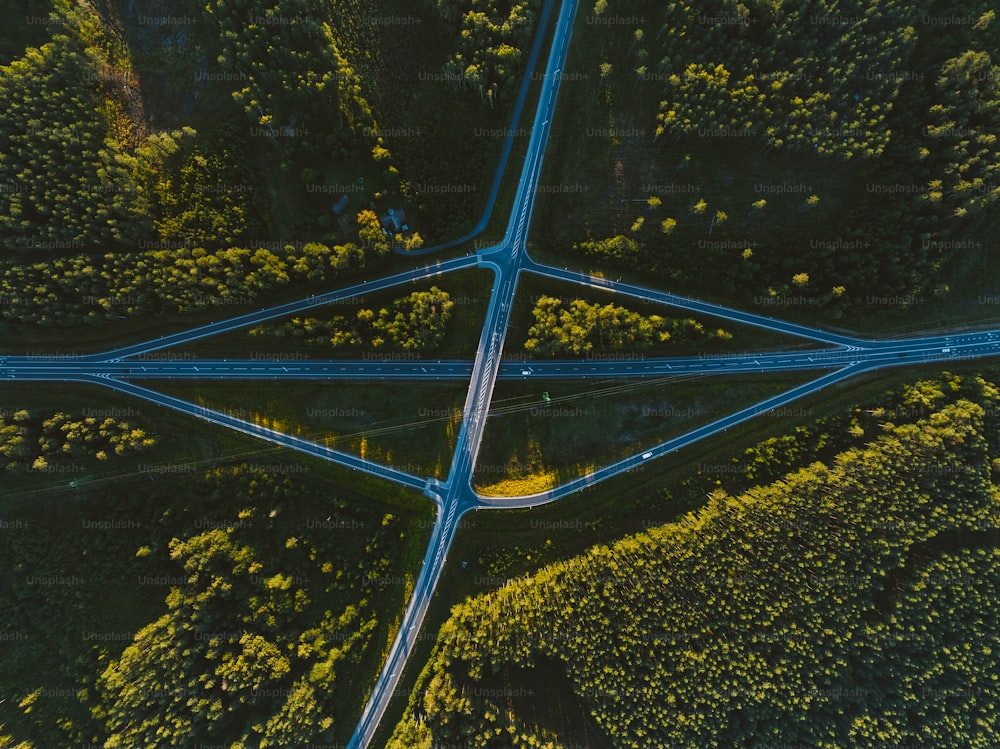 an aerial view of a road intersection in the middle of a forest