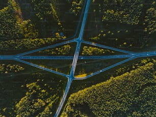 an aerial view of a road intersection in the middle of a forest