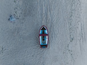 Un pequeño bote flotando en la cima de una playa de arena