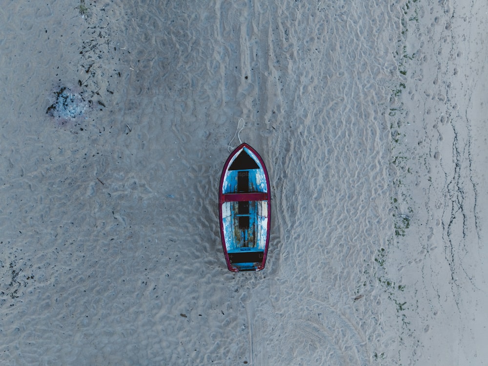 Un pequeño bote flotando en la cima de una playa de arena