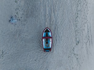 a small boat floating on top of a sandy beach