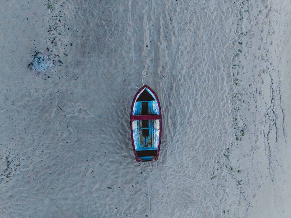 a small boat floating on top of a sandy beach