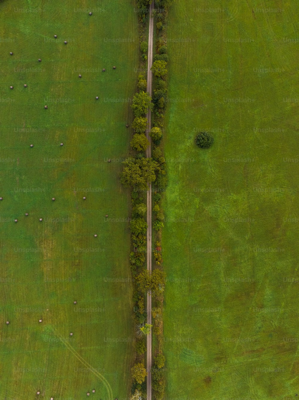 an aerial view of a road in a green field