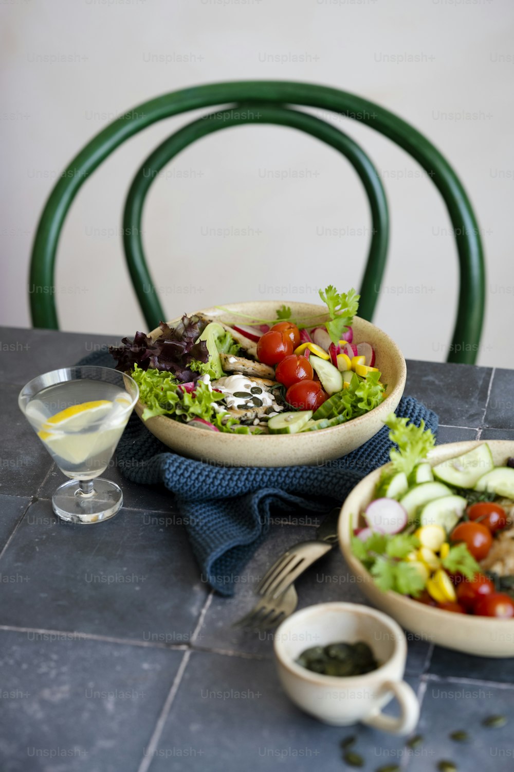 a table with a bowl of salad and a glass of wine