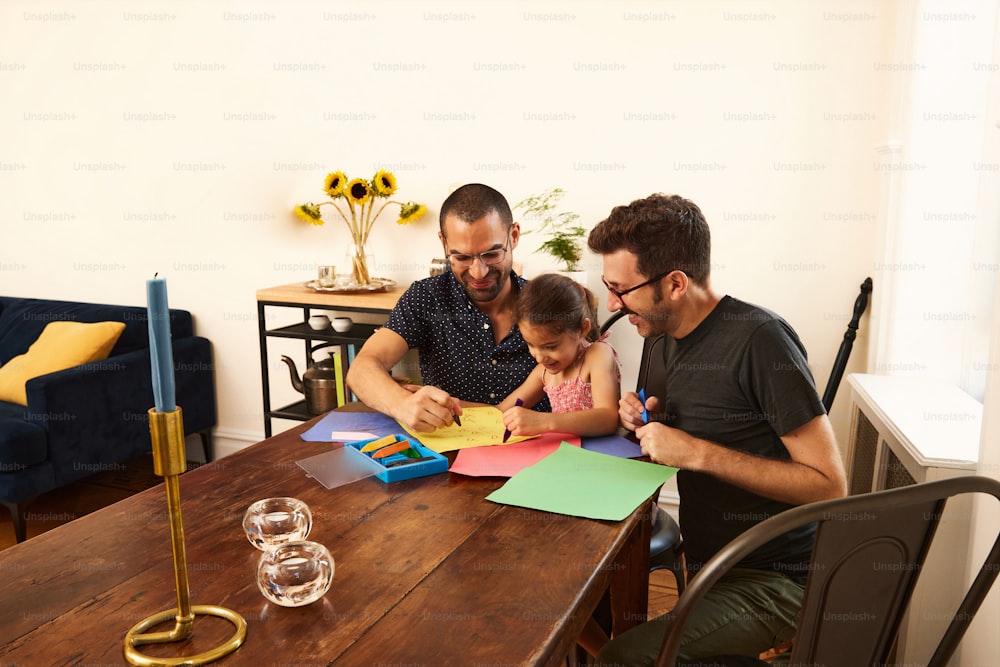 Un hombre y dos niños sentados en una mesa
