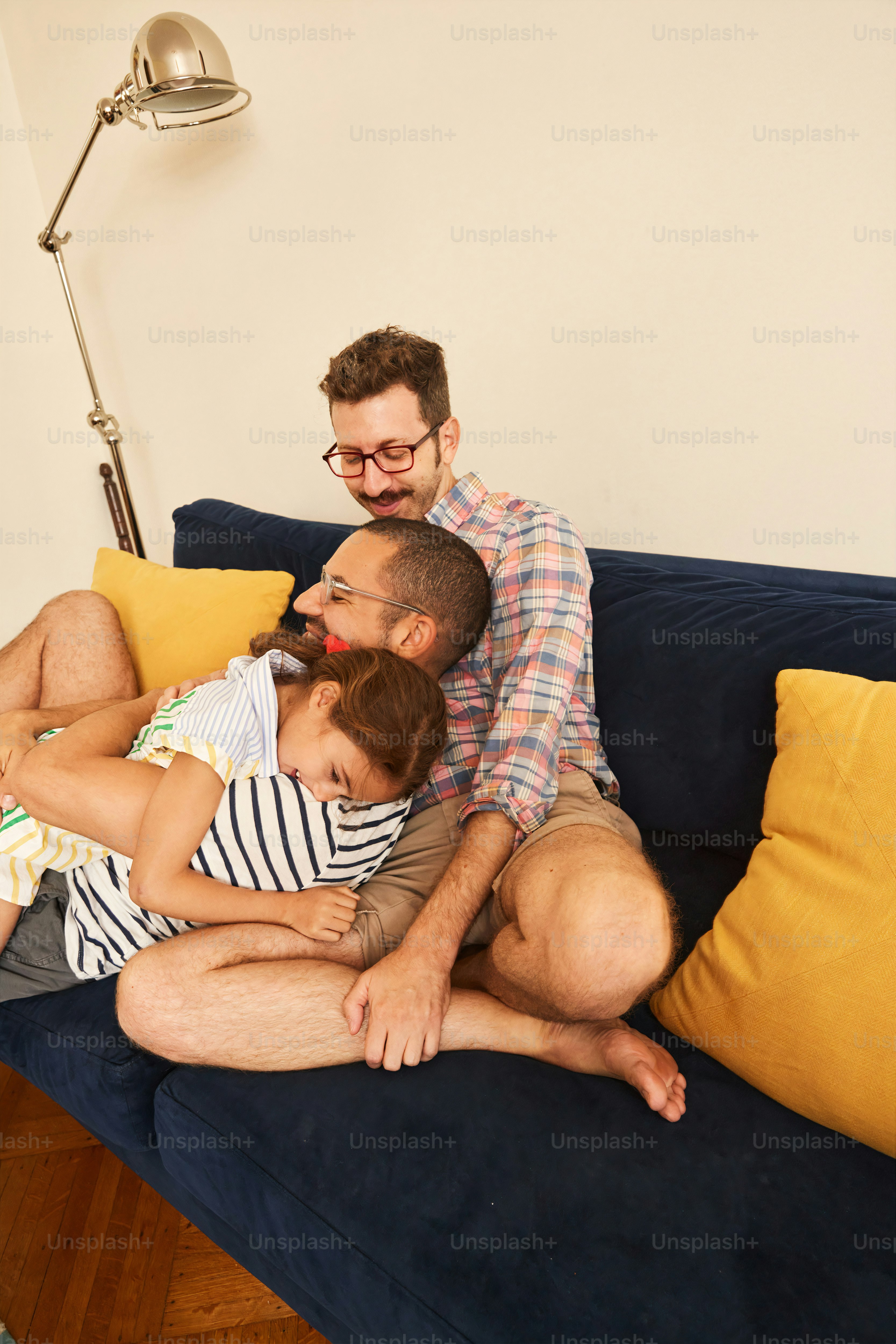a man sitting on a couch with two children