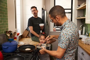 a man and a little girl cooking in a kitchen