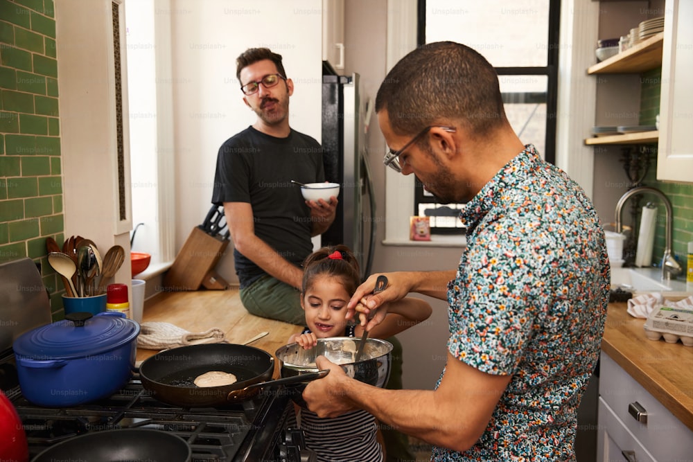 a man and a little girl cooking in a kitchen