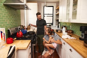 2人の子供と一緒に台所に立つ男