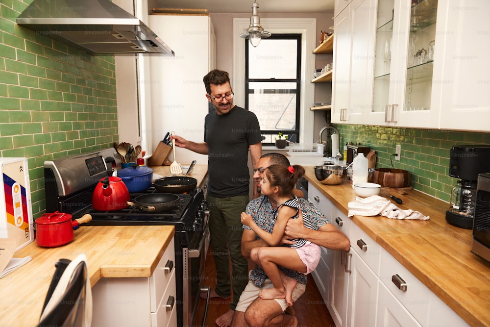a man standing in a kitchen with two children
