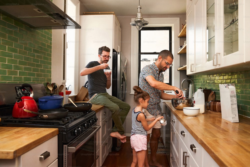 a man and two little girls standing in a kitchen