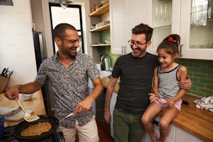 a man and two girls cooking in a kitchen
