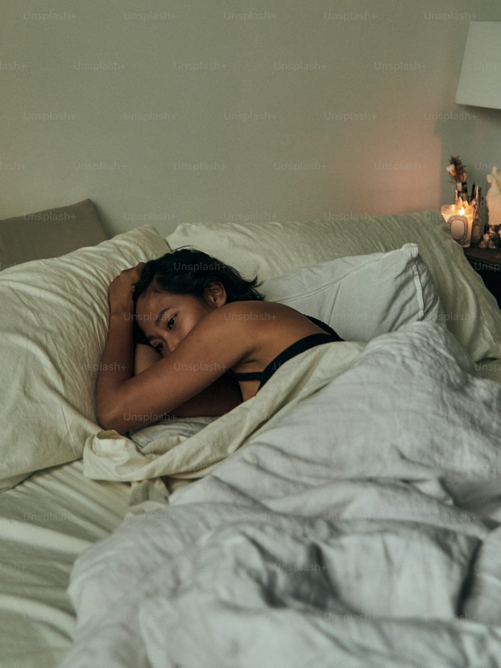 Eine Frau, die mit dem Kopf auf einem Kissen im Bett liegt
