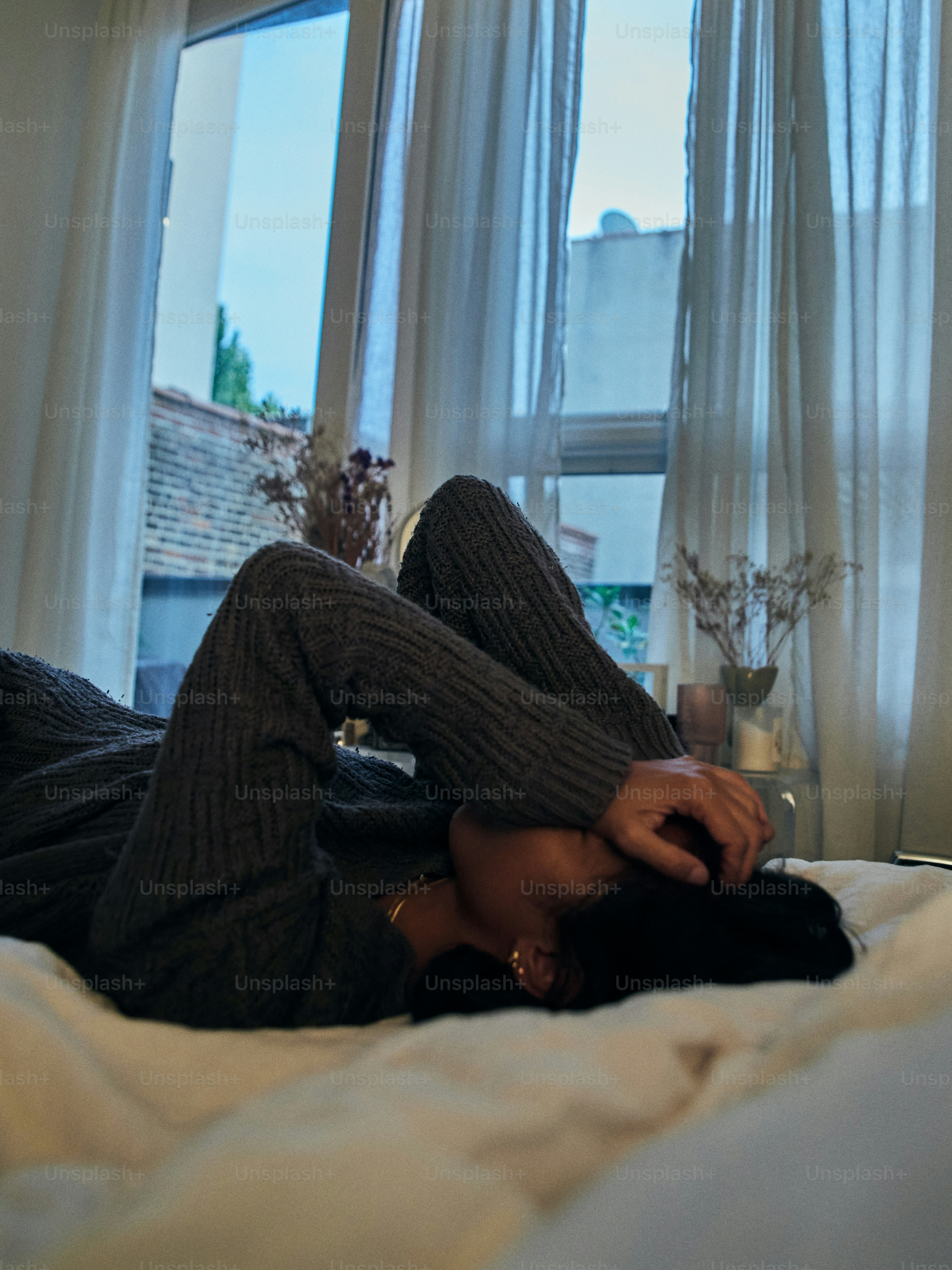 Eine Frau, die mit gekreuzten Beinen auf einem Bett liegt