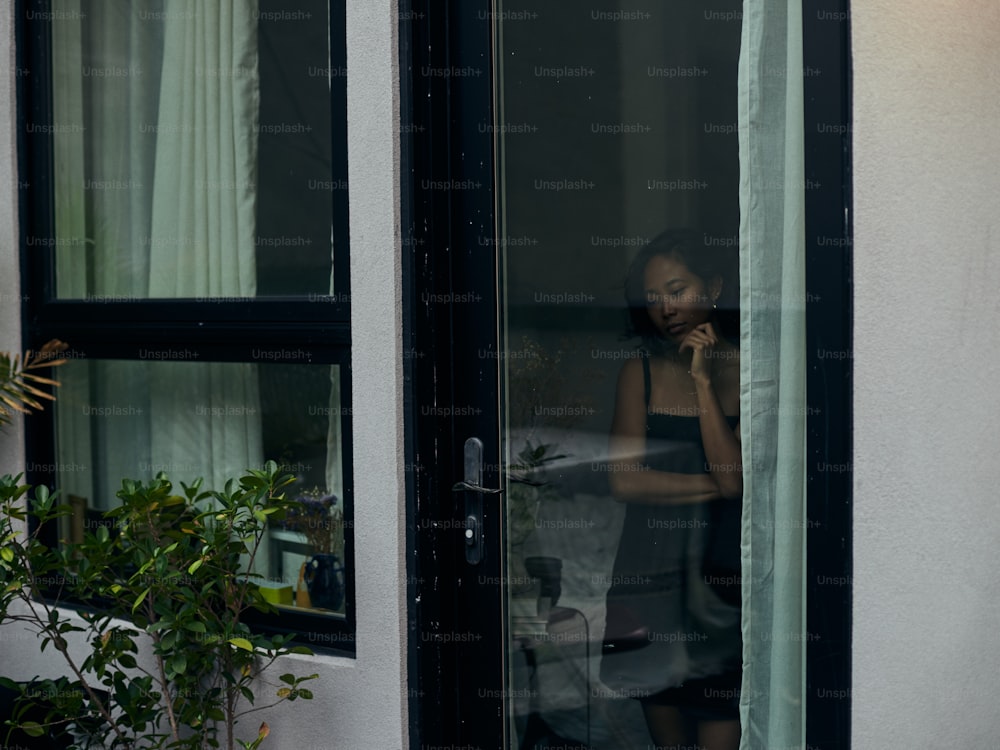 Una mujer hablando por un teléfono celular en una ventana