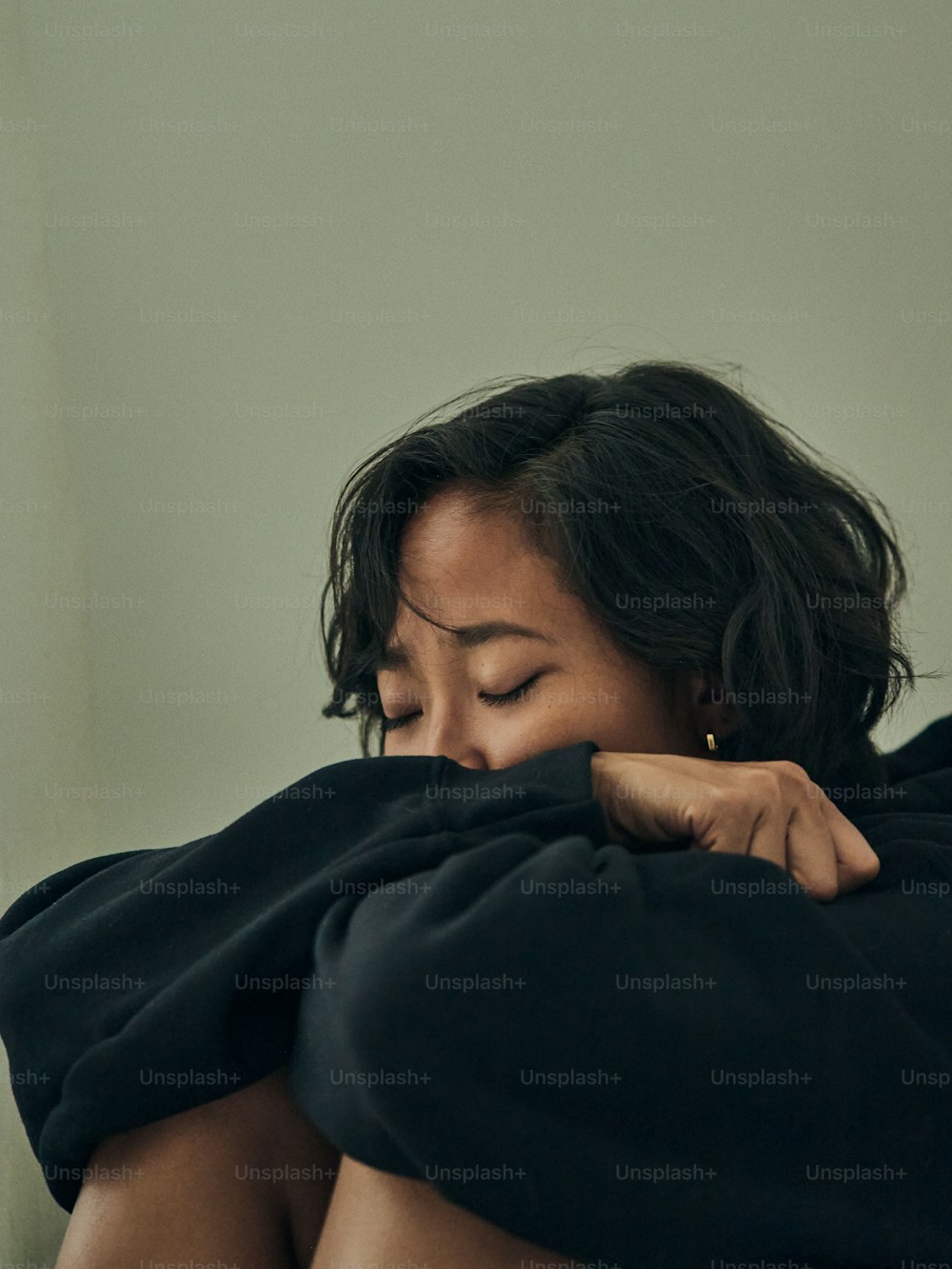 a woman is wrapped in a black blanket