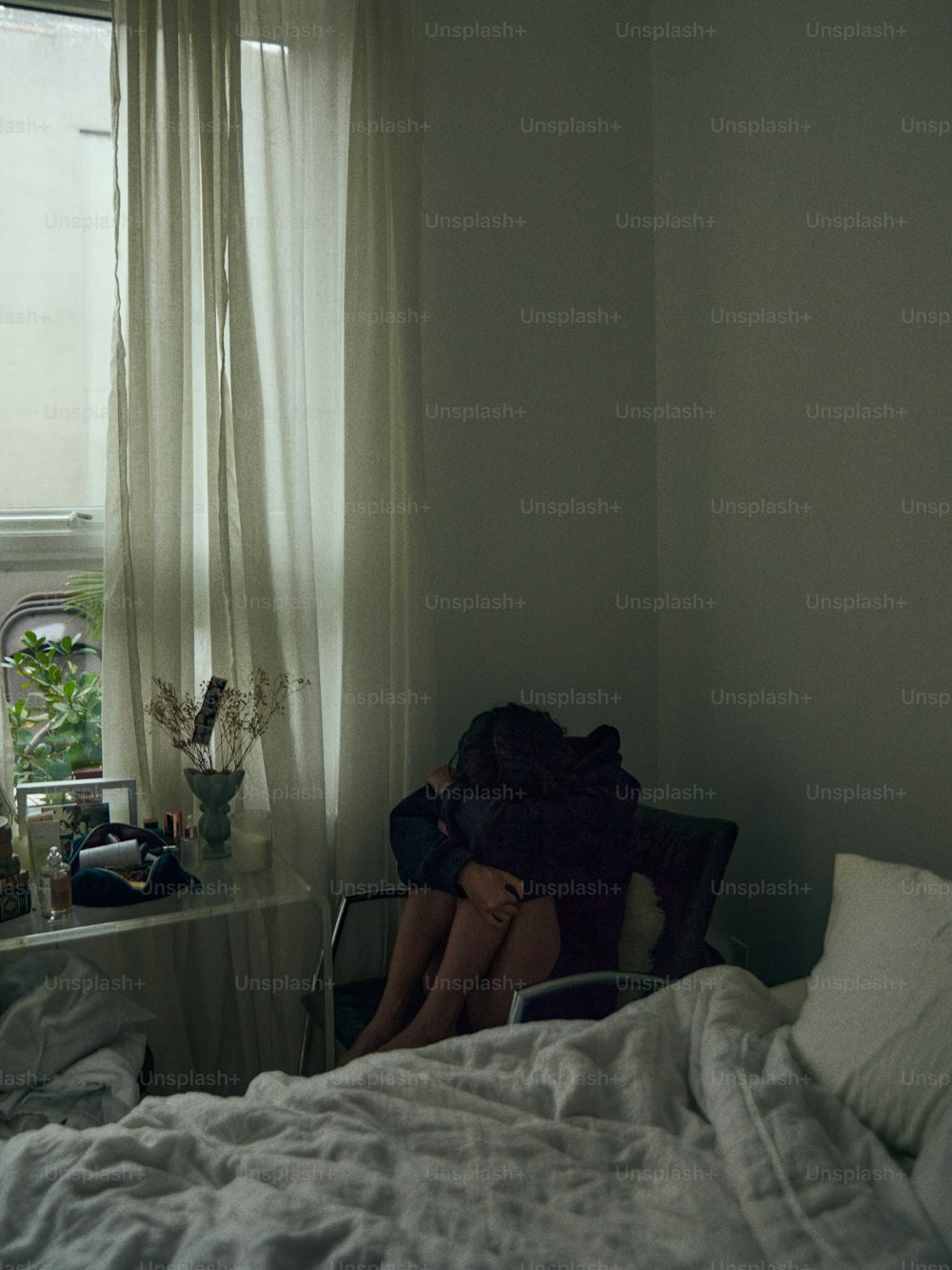 a woman sitting in a chair in front of a window