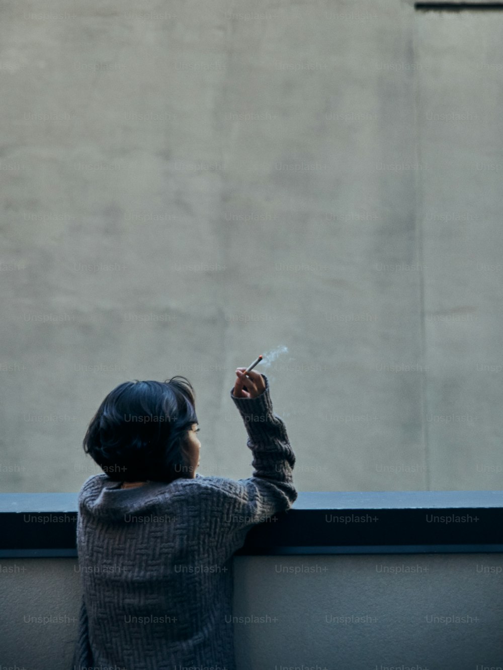 a little girl that is holding a cigarette