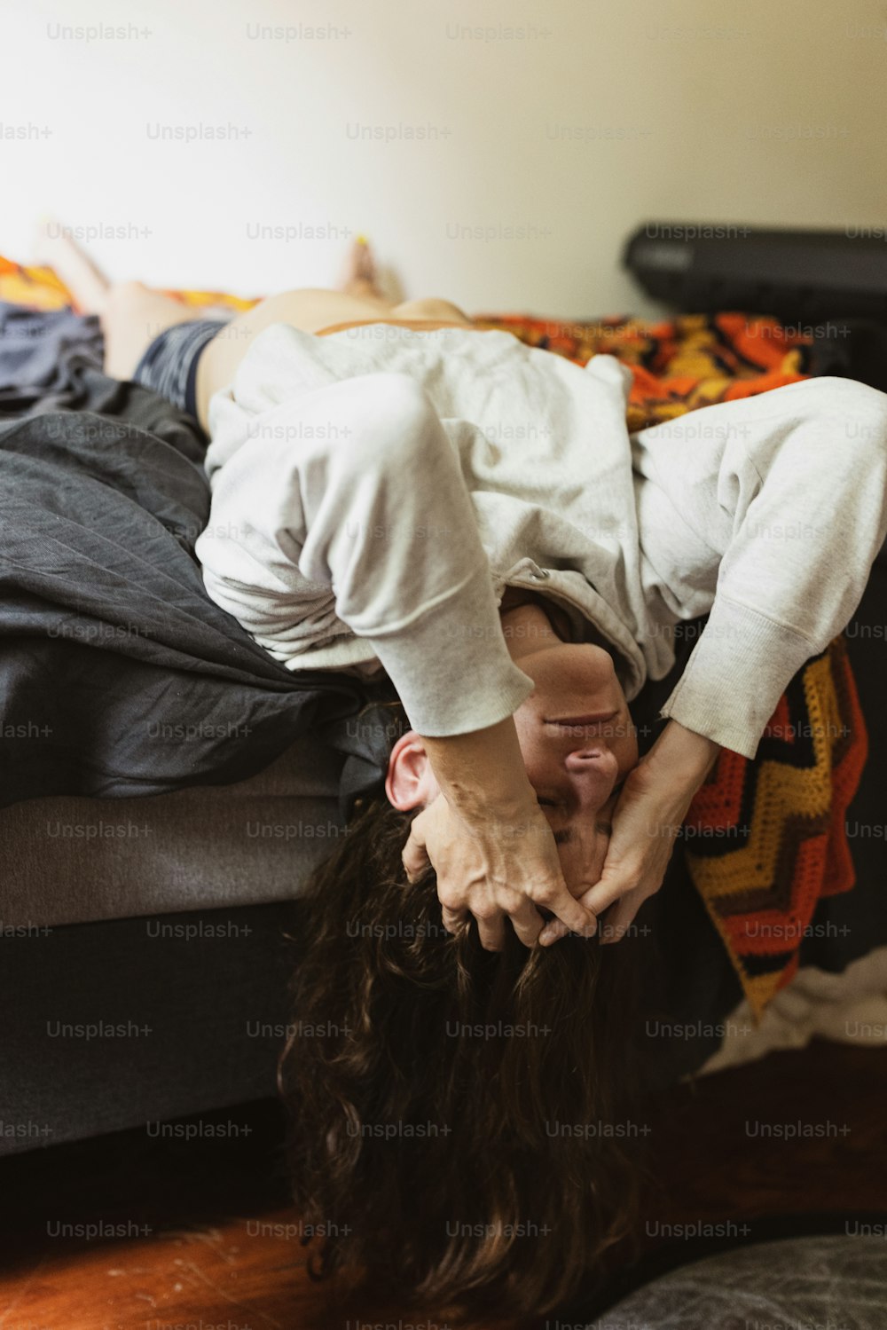 a person is upside down on a bed
