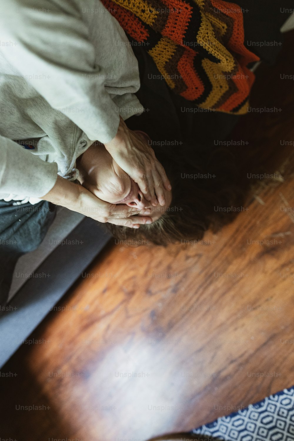 a person standing on a wooden floor with their hands together