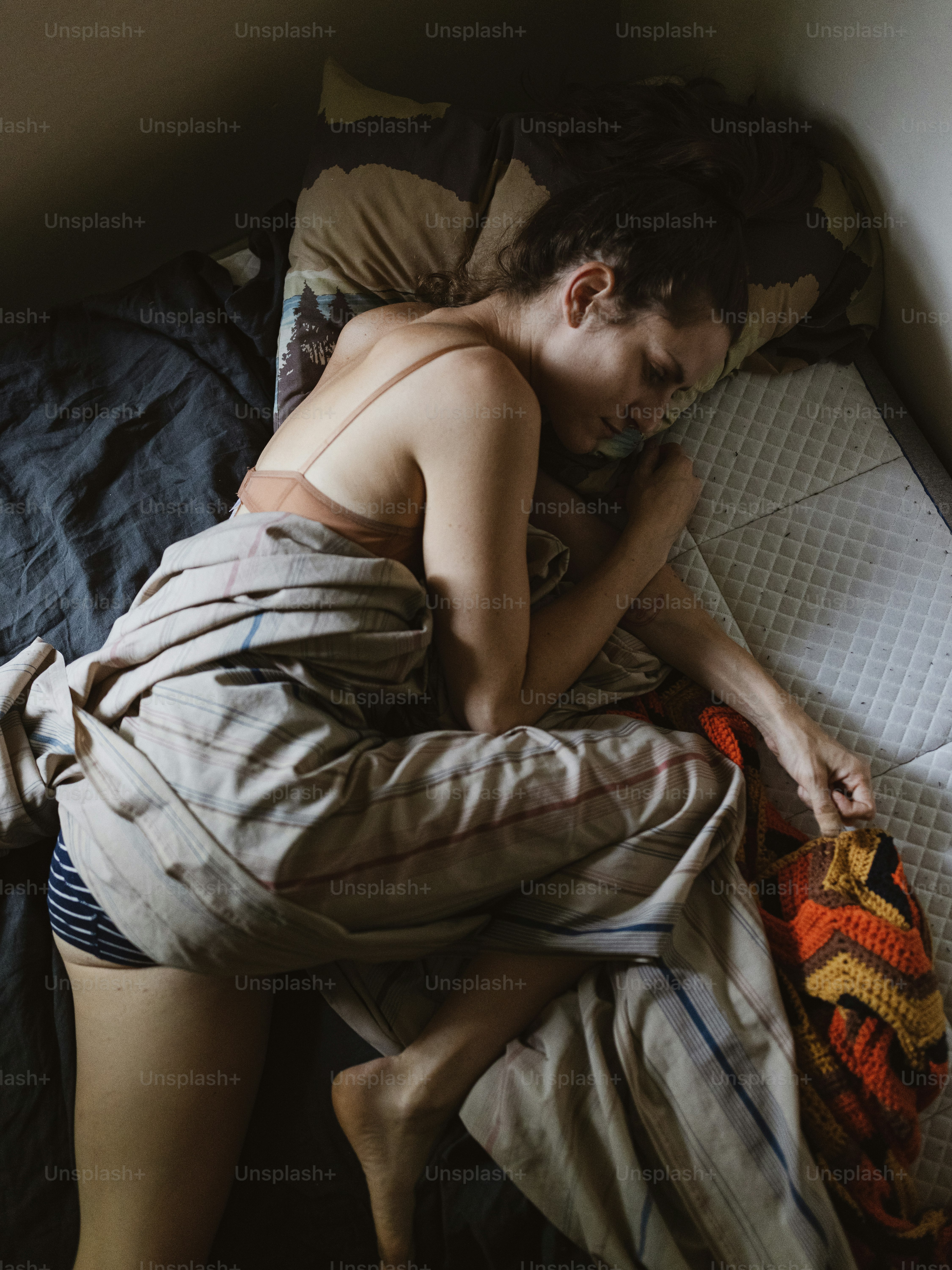 ein Mann ohne Hemd, der auf einem Bett schläft