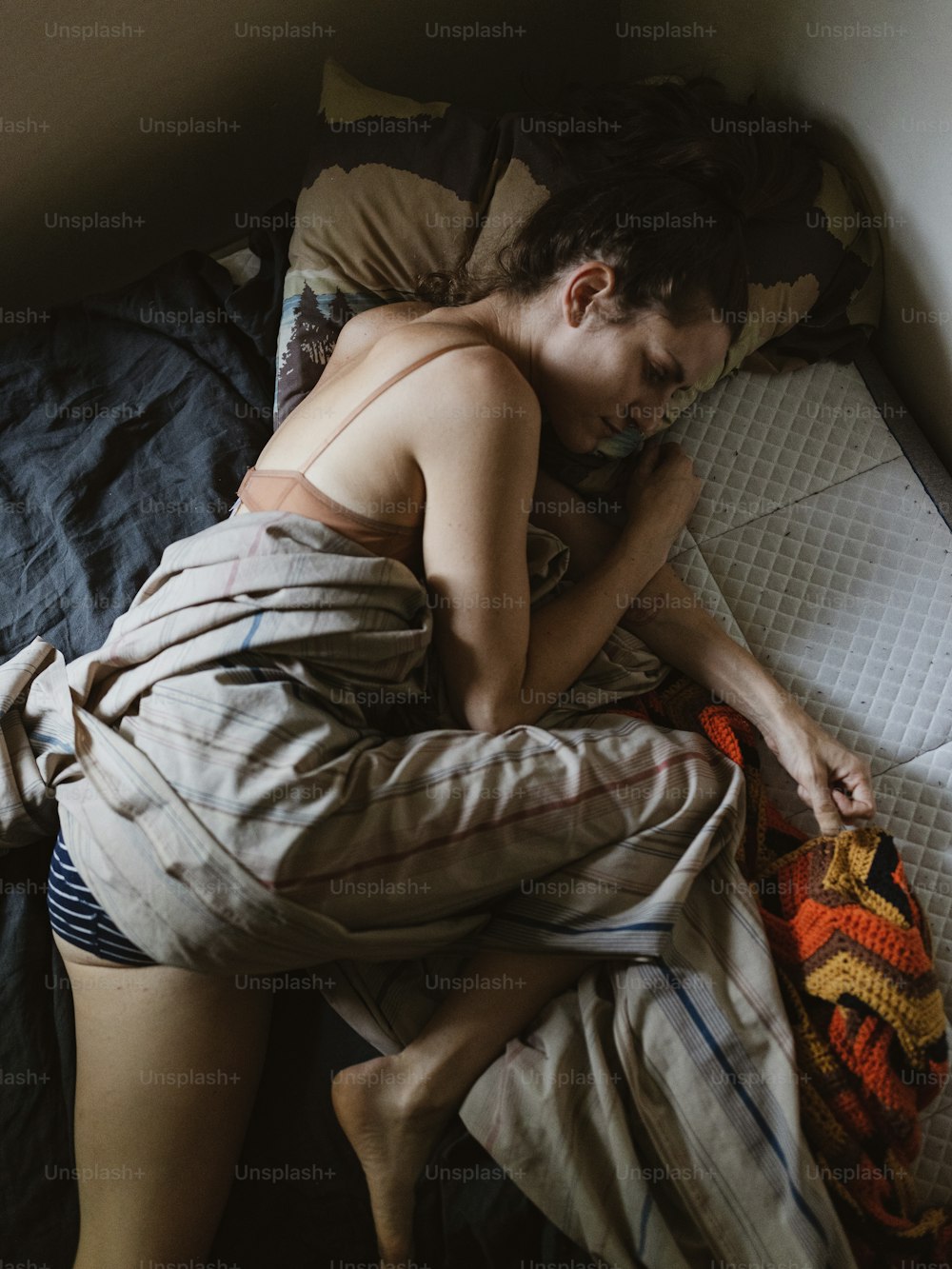 침대에서 자고 있는 셔츠 없는 남자