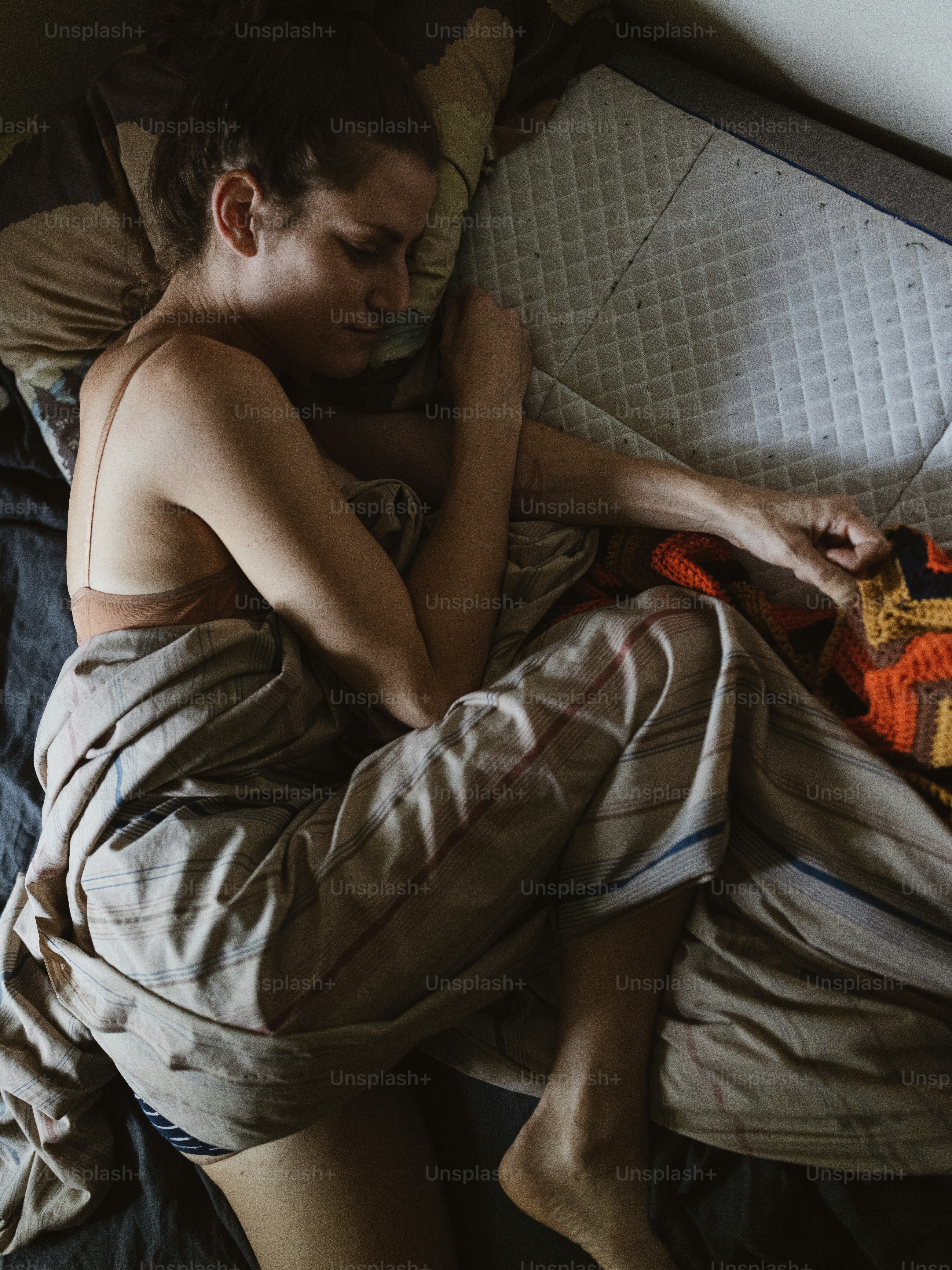 a man laying on a bed with a blanket