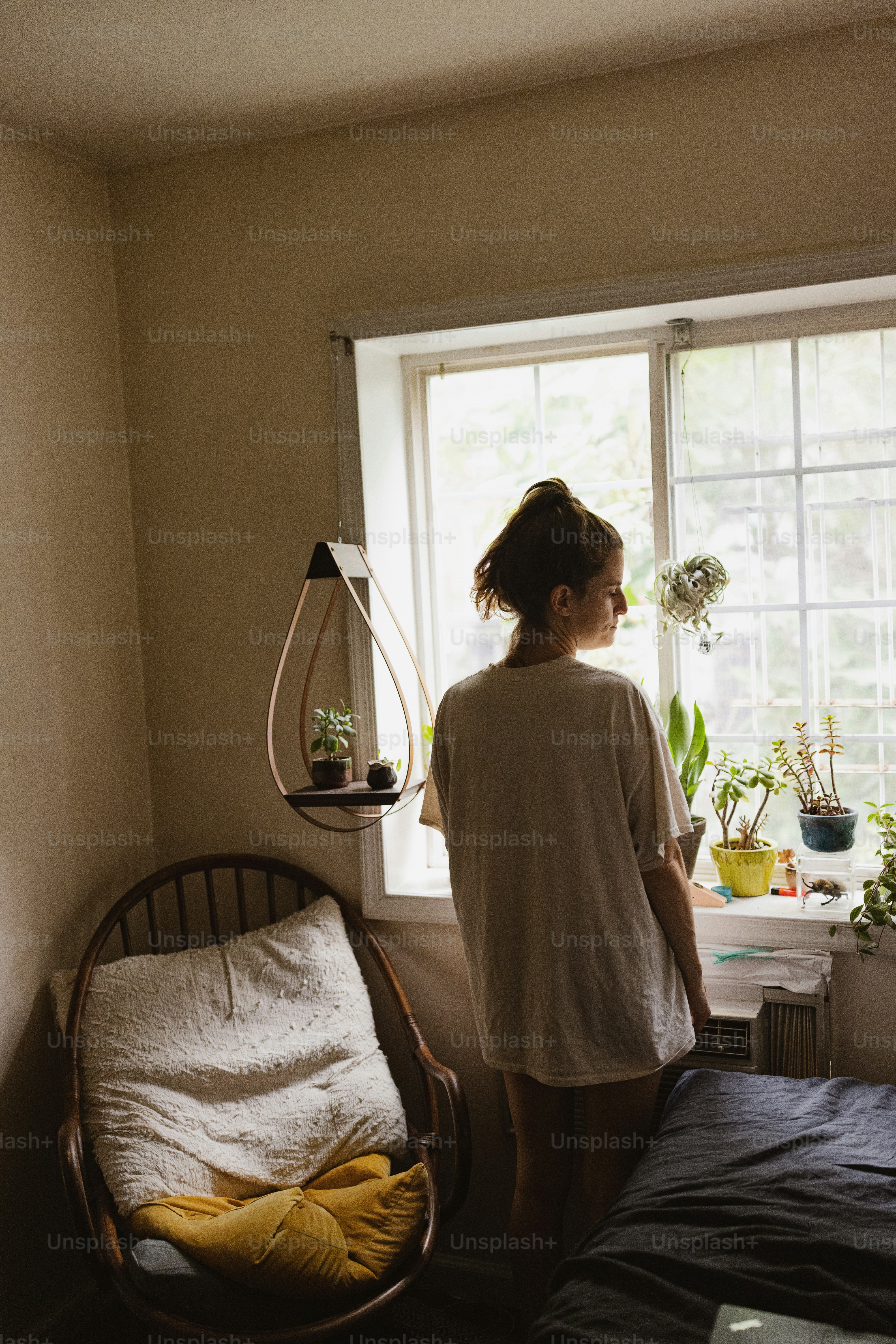 Eine Frau, die vor einem Fenster steht und hinausschaut
