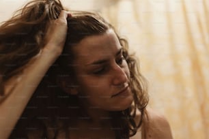 uma mulher está secando o cabelo no banheiro